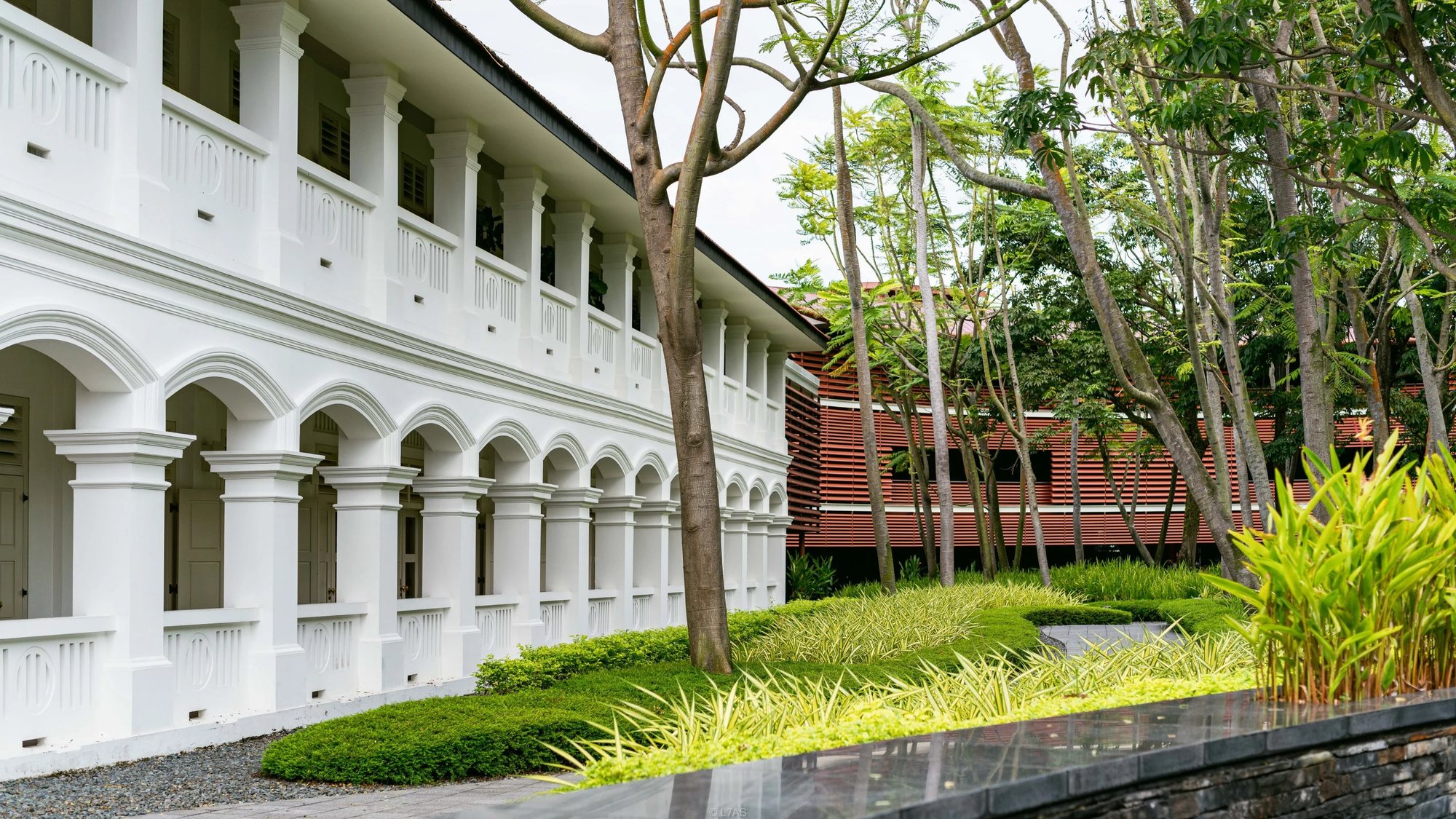 Arched verandahs of the 1880s building beside the gardens