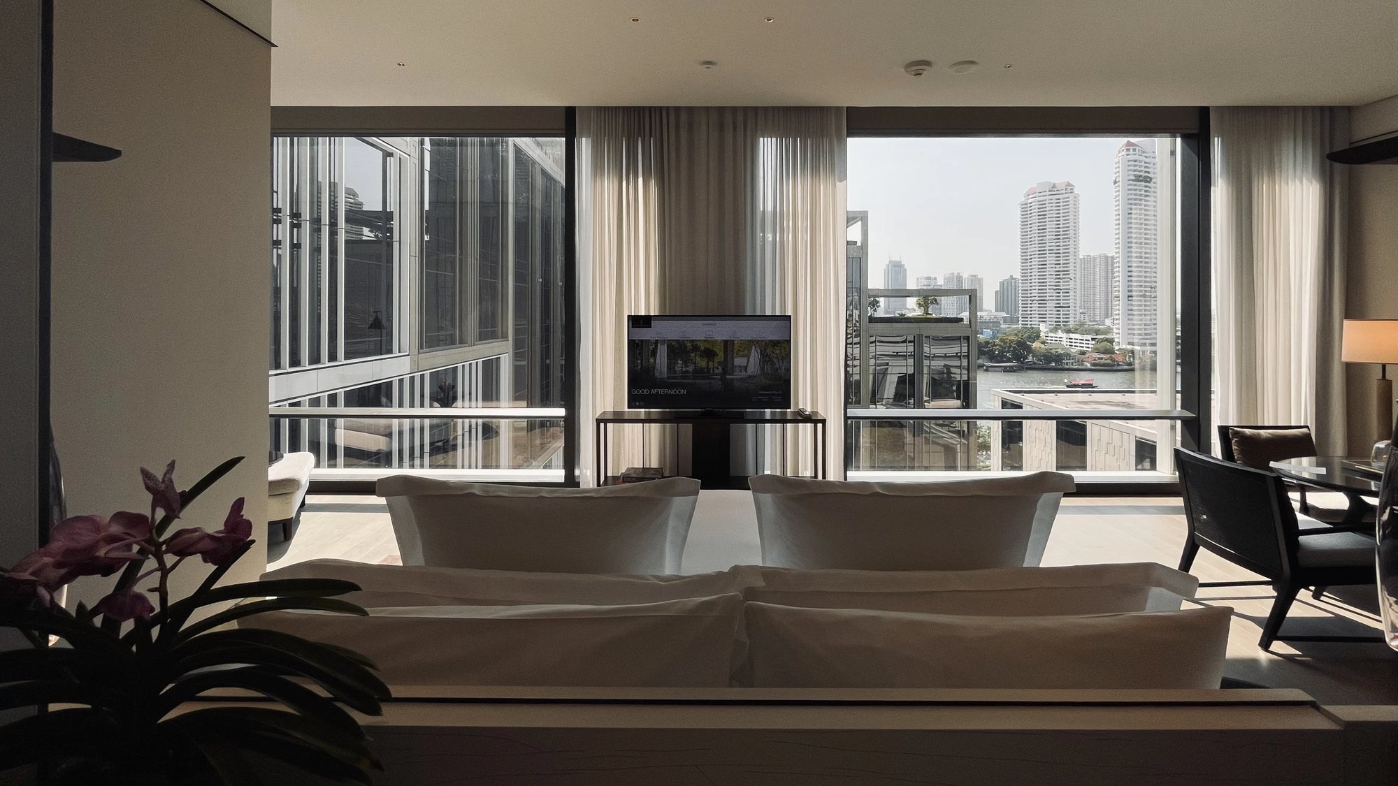 Across the suite to the river and the far bank's towers
