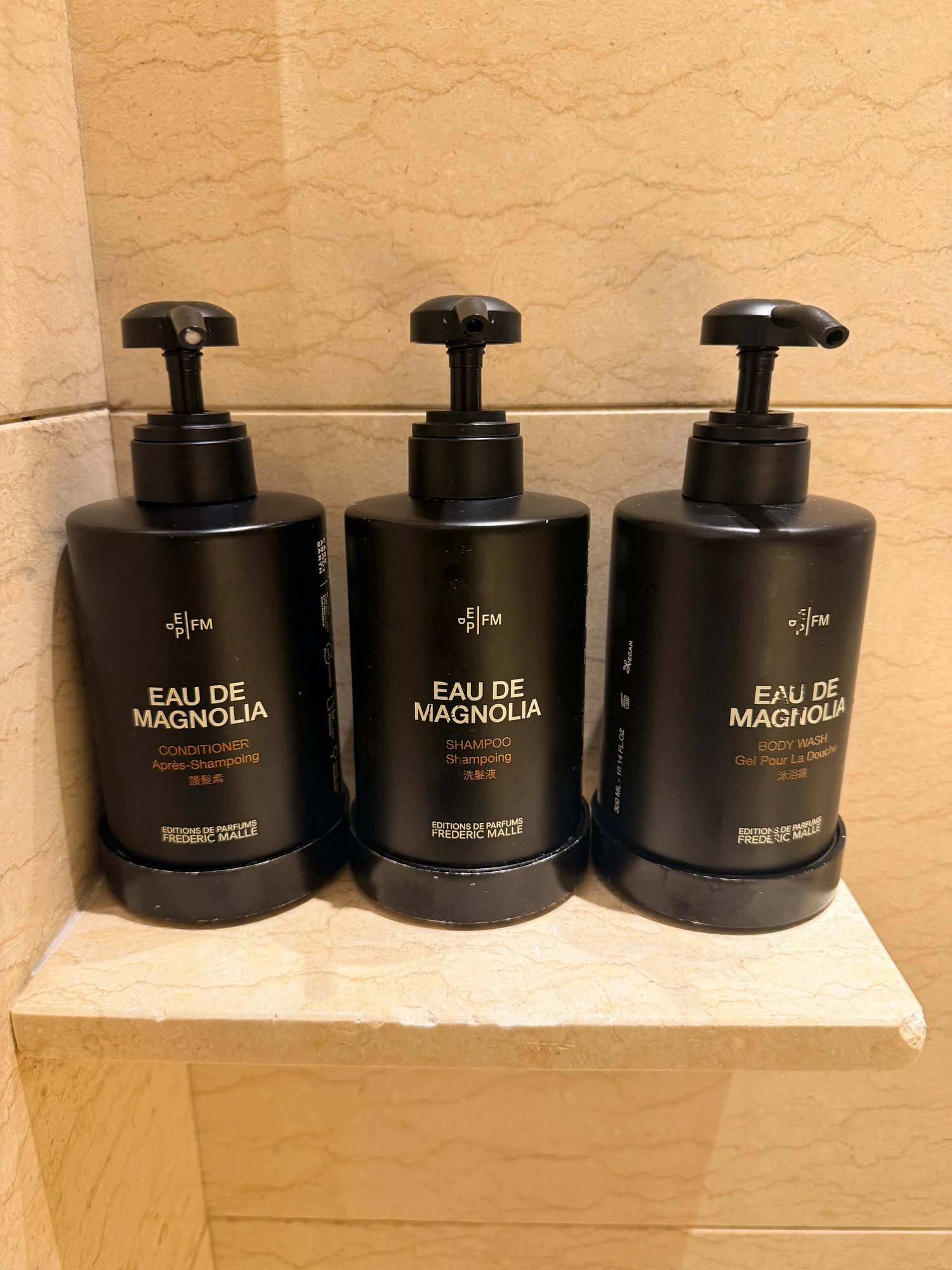 Eau de Magnolia bath amenities on a marble shelf