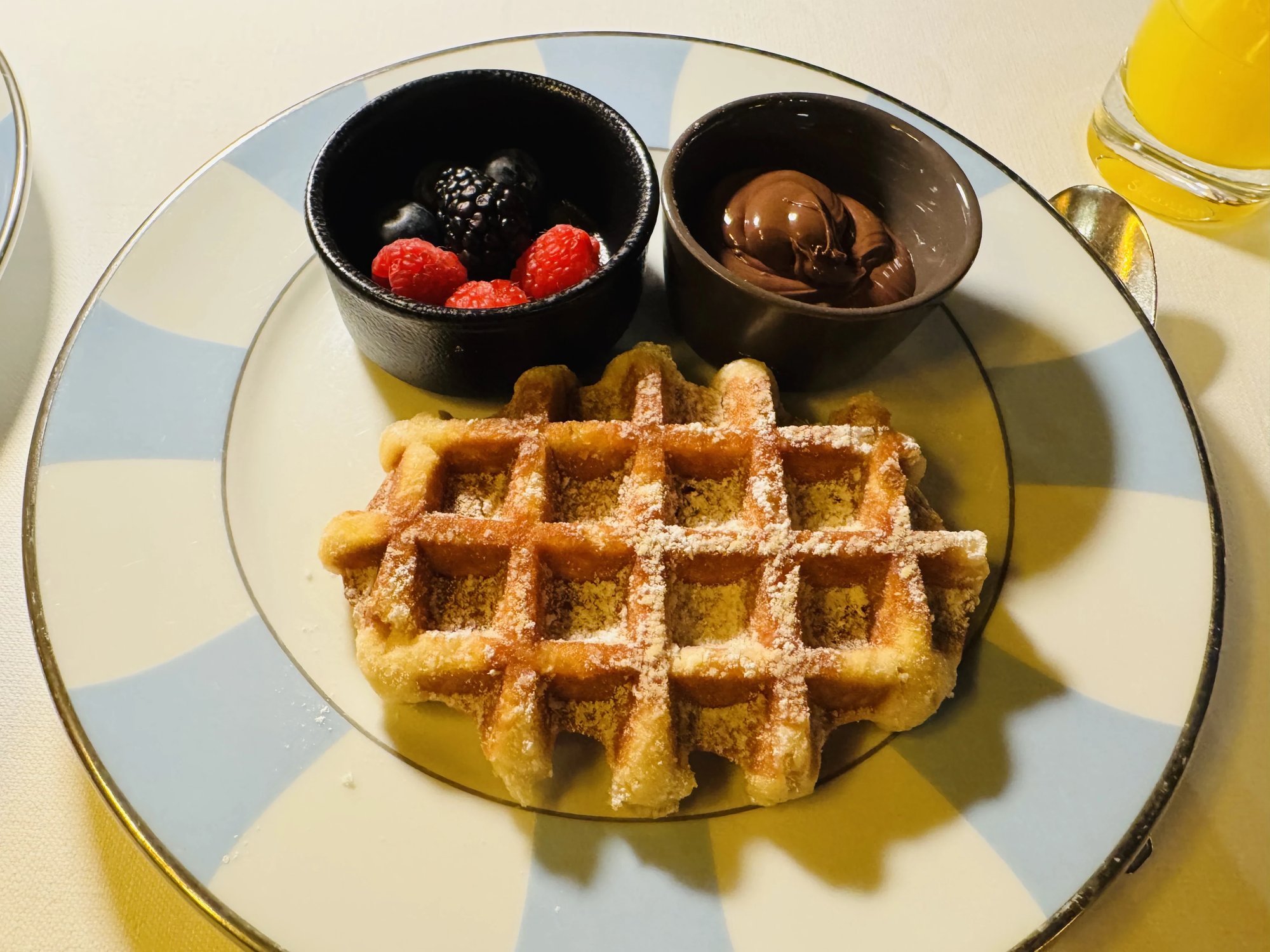 A waffle with berries and chocolate at breakfast