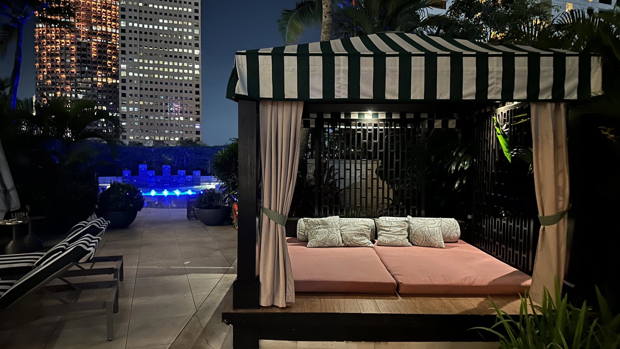 A striped cabana by the pool at night