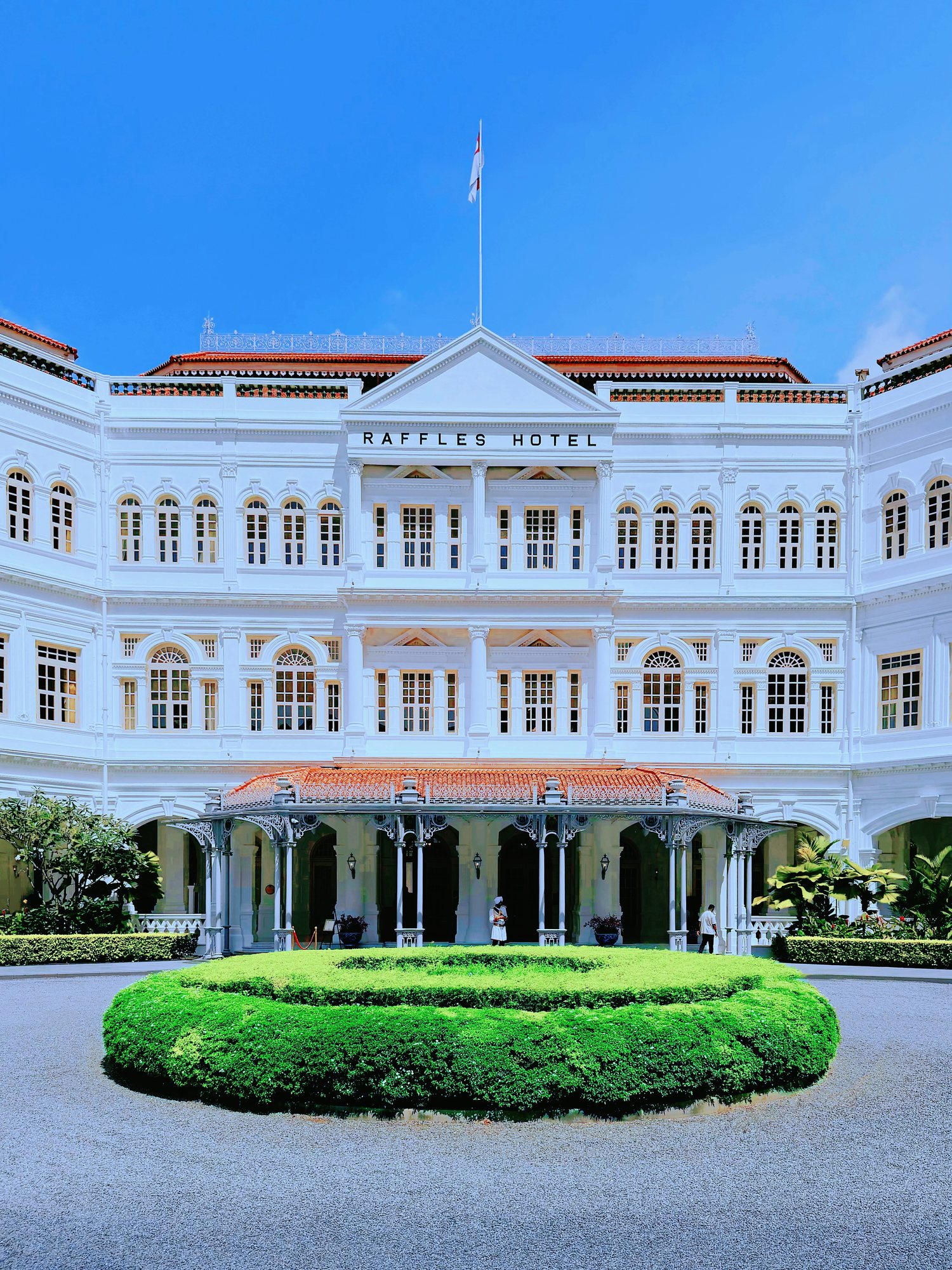 The white colonial facade of Raffles Hotel with its cast-iron porch