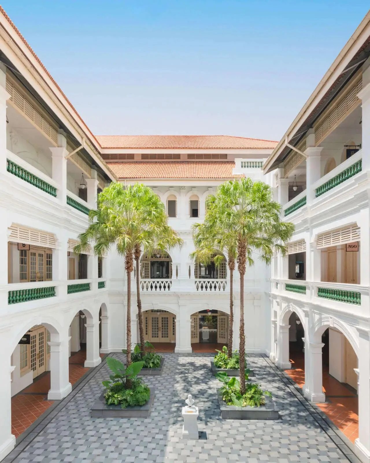A courtyard of white verandahs and palms