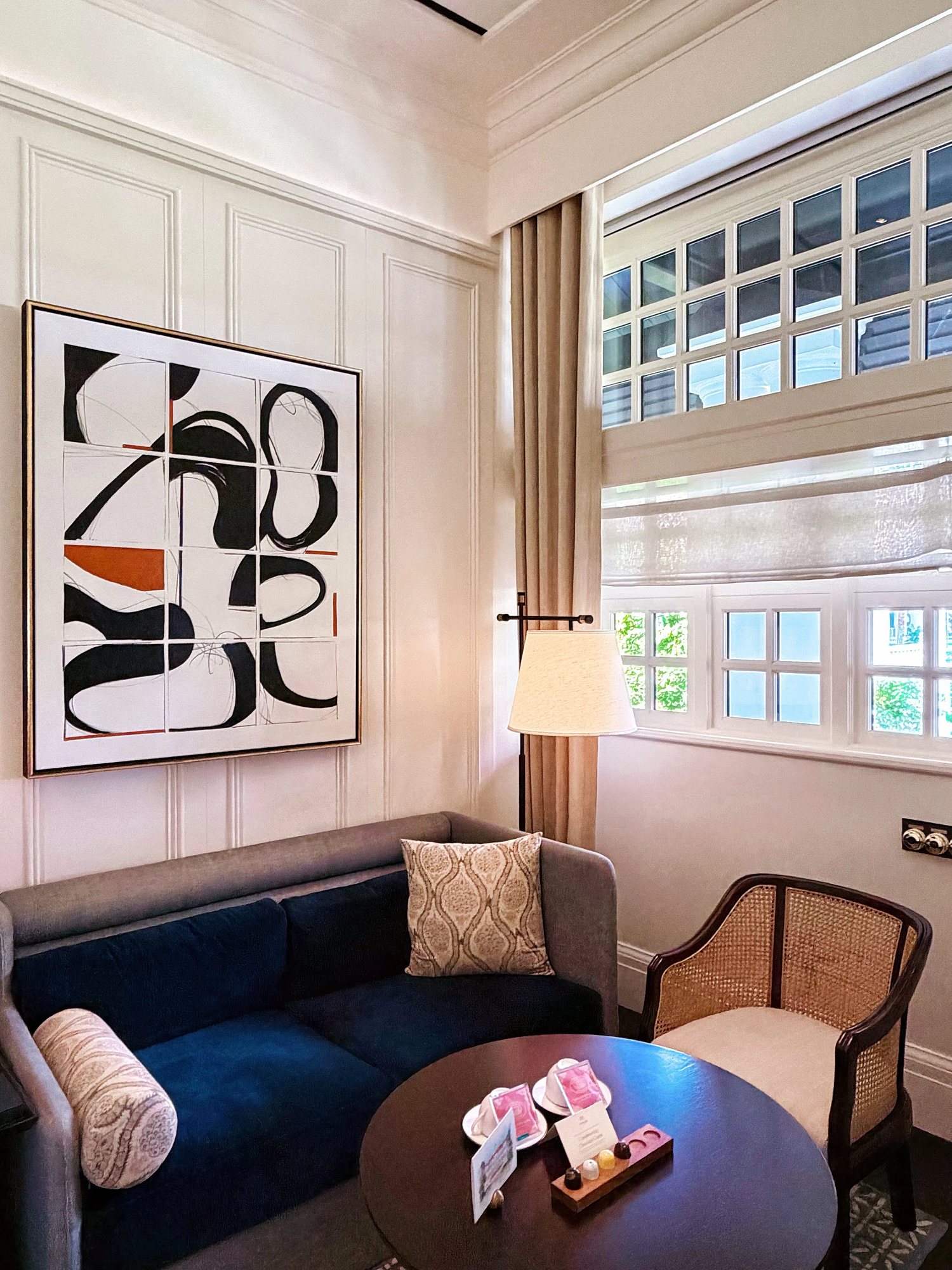 The suite parlour with a navy sofa and rattan chairs