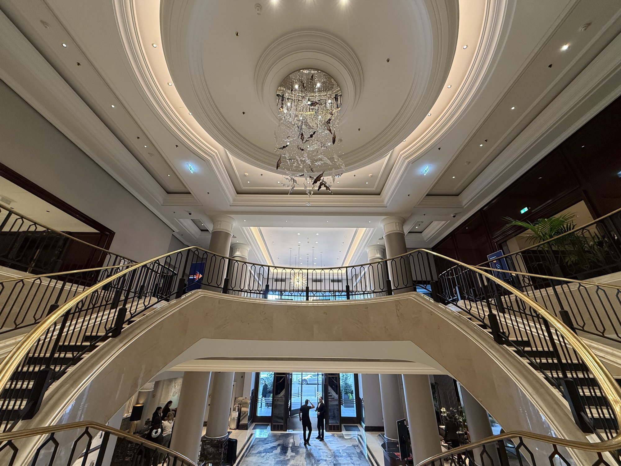 The sweeping double staircase under a domed ceiling in the hotel lobby