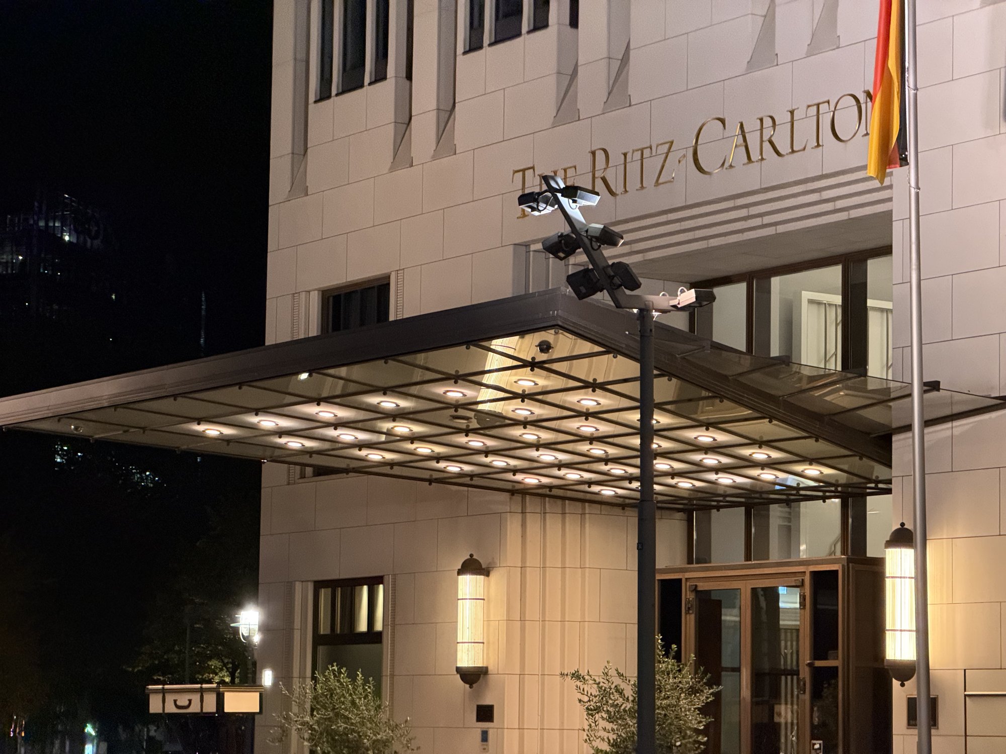 The entrance canopy and flag at night, lit from beneath