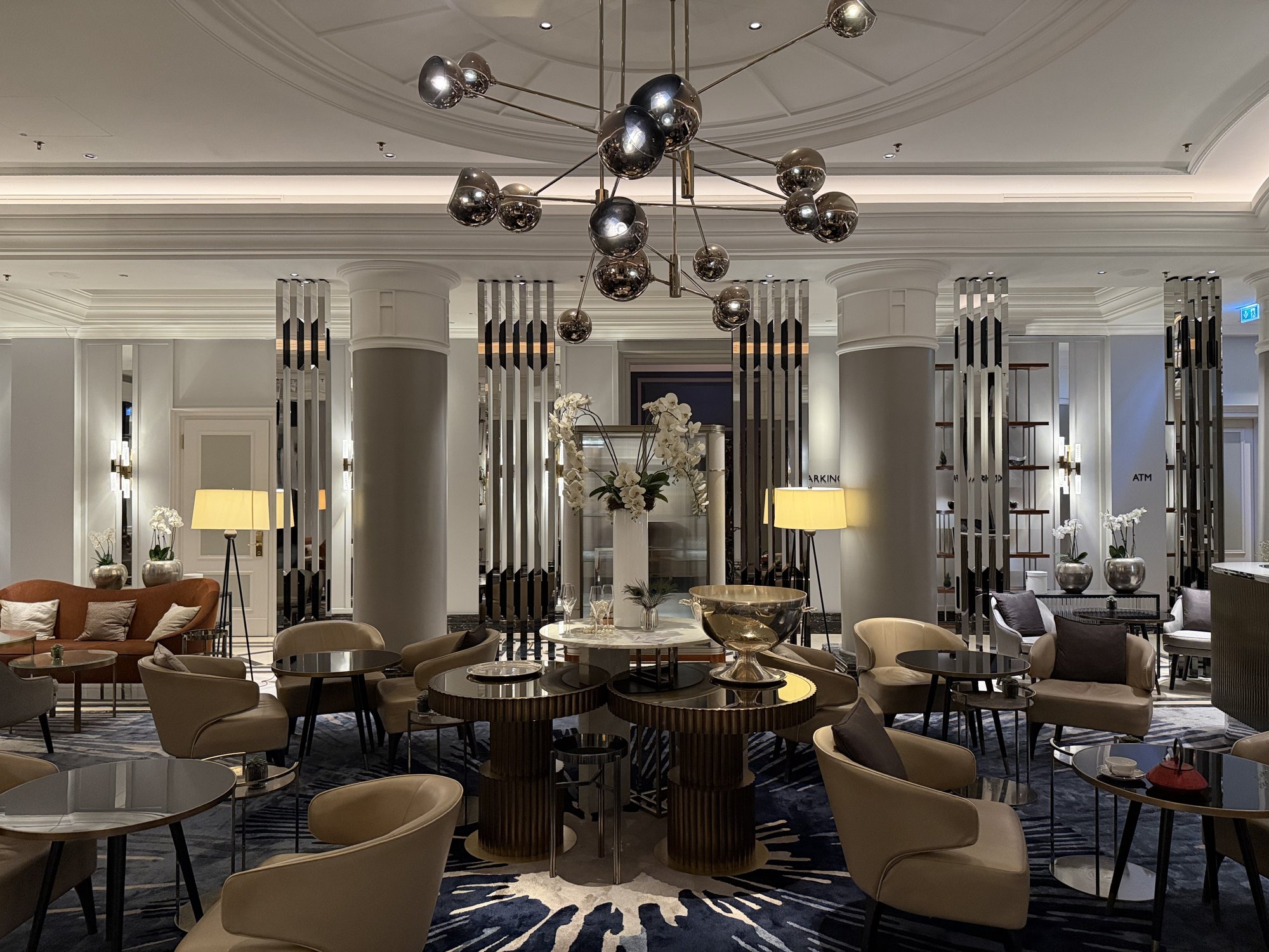 A lounge with a sputnik chandelier and low seating