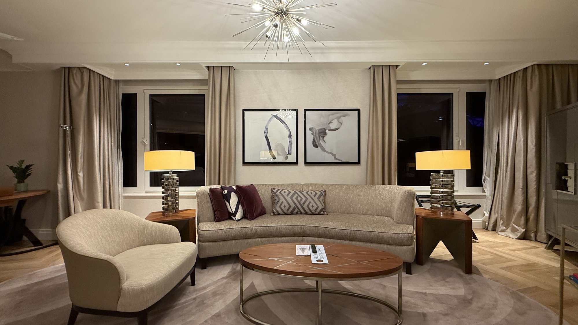 The living room with a curved sofa and starburst light