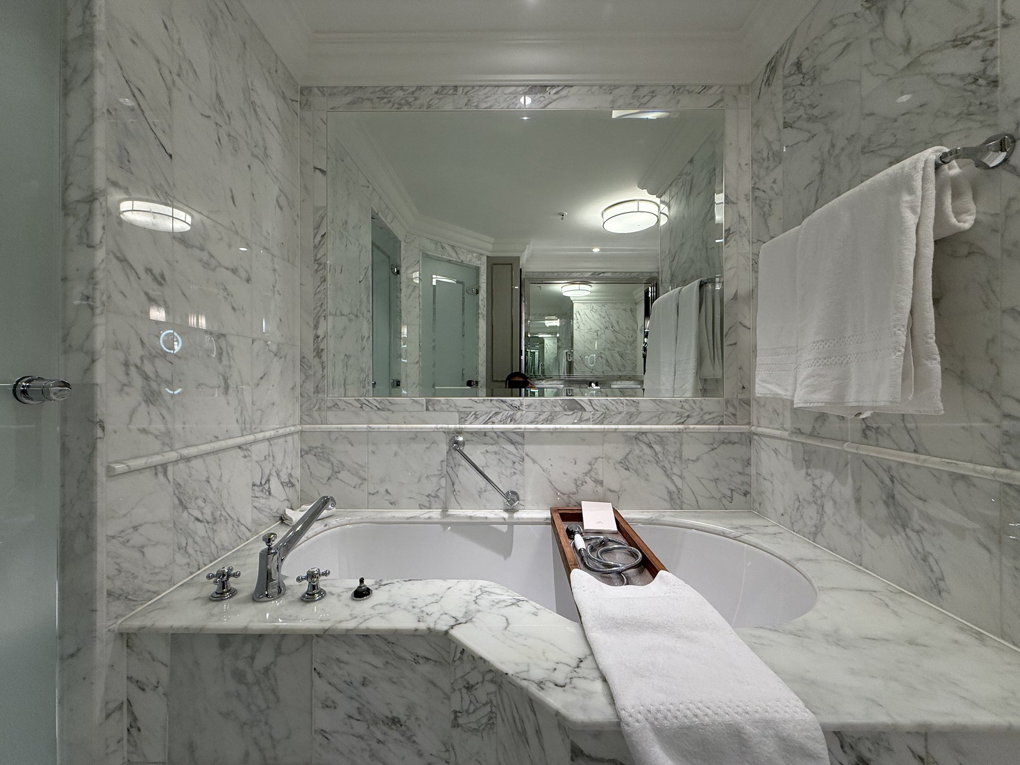 The marble bathtub with a wooden tray