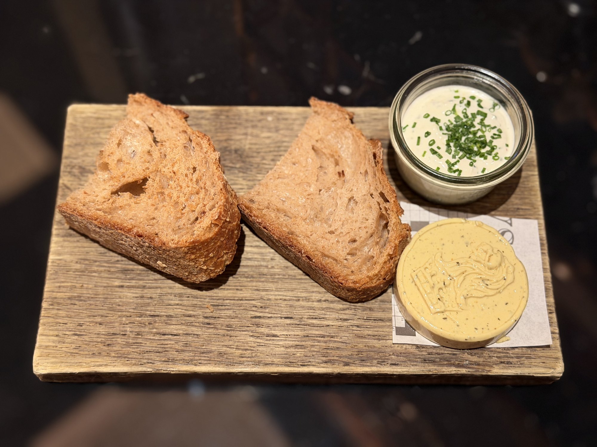 Bread and butter on a wooden board at POTS