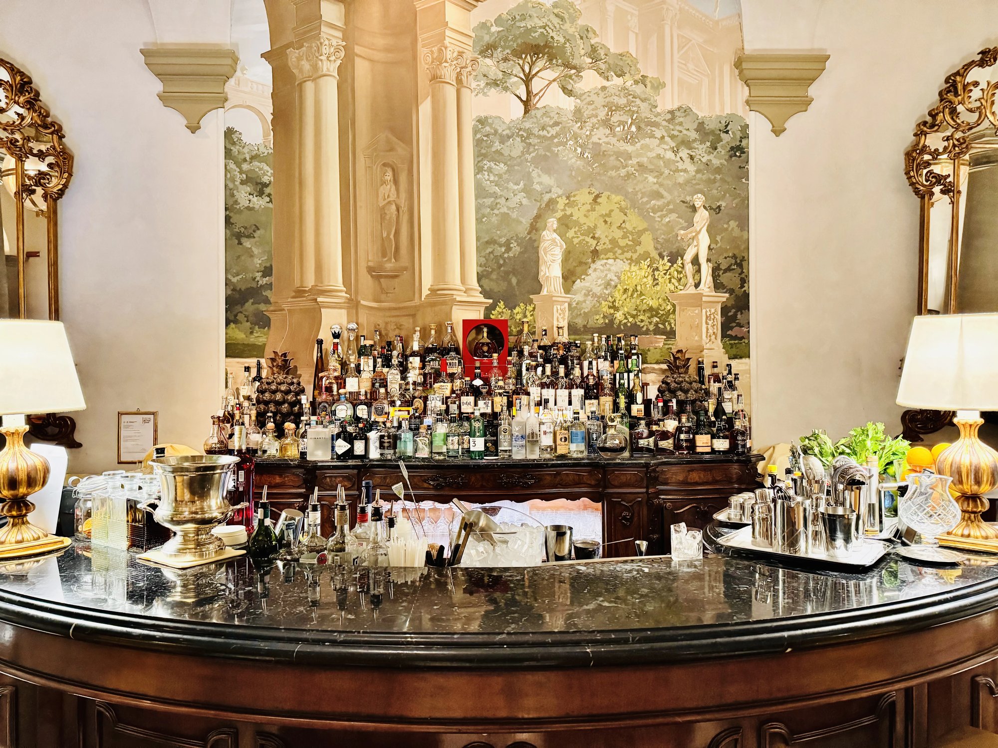 The Winter Garden bar with a marble counter in front of a mural