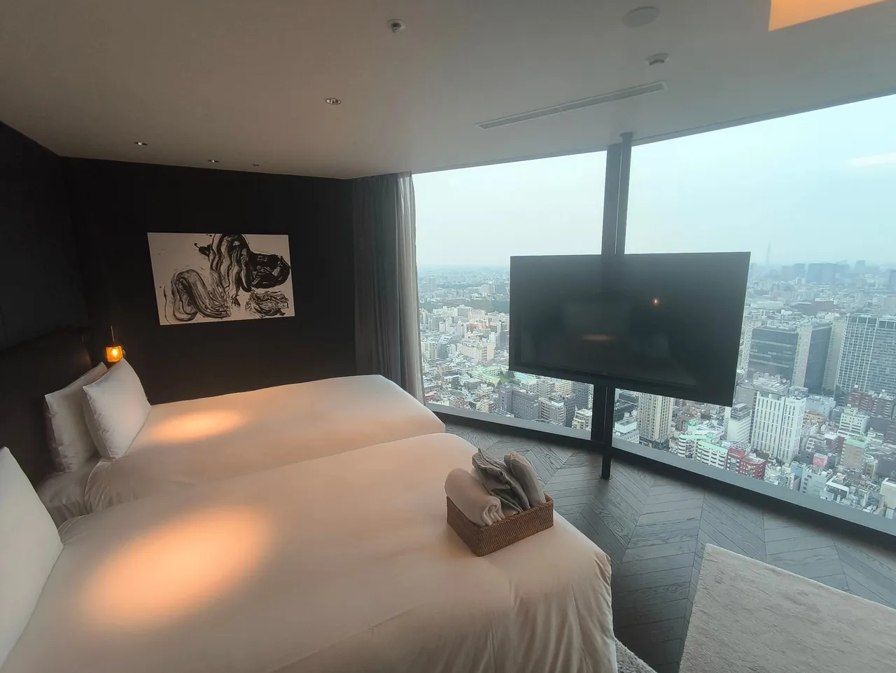 The twin corner suite with two beds facing floor-to-ceiling windows over Tokyo