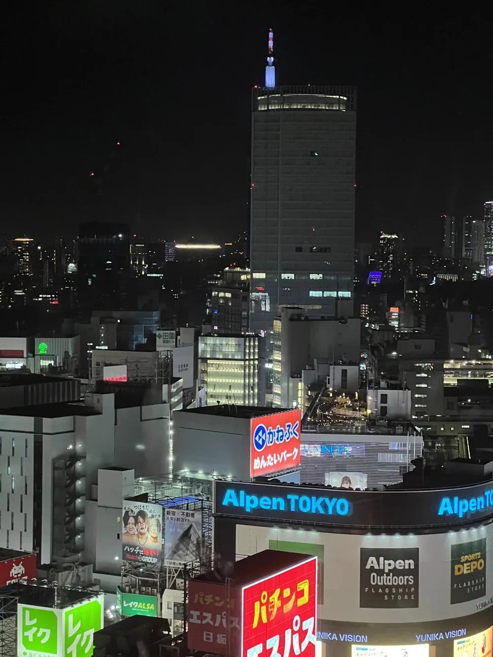 Kabukicho neon at night with a lit tower beyond