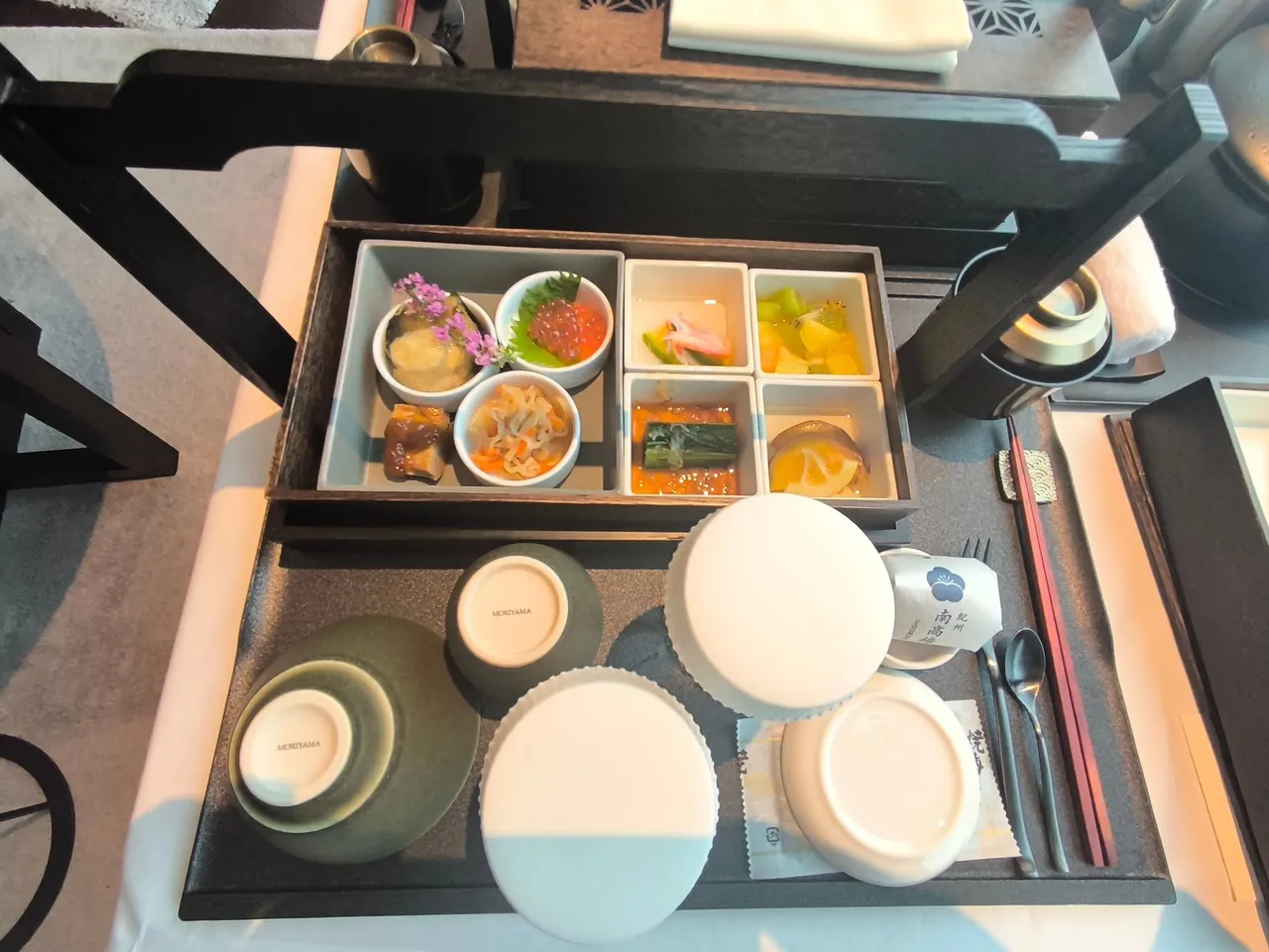 A Japanese breakfast box on a tray with small bowls