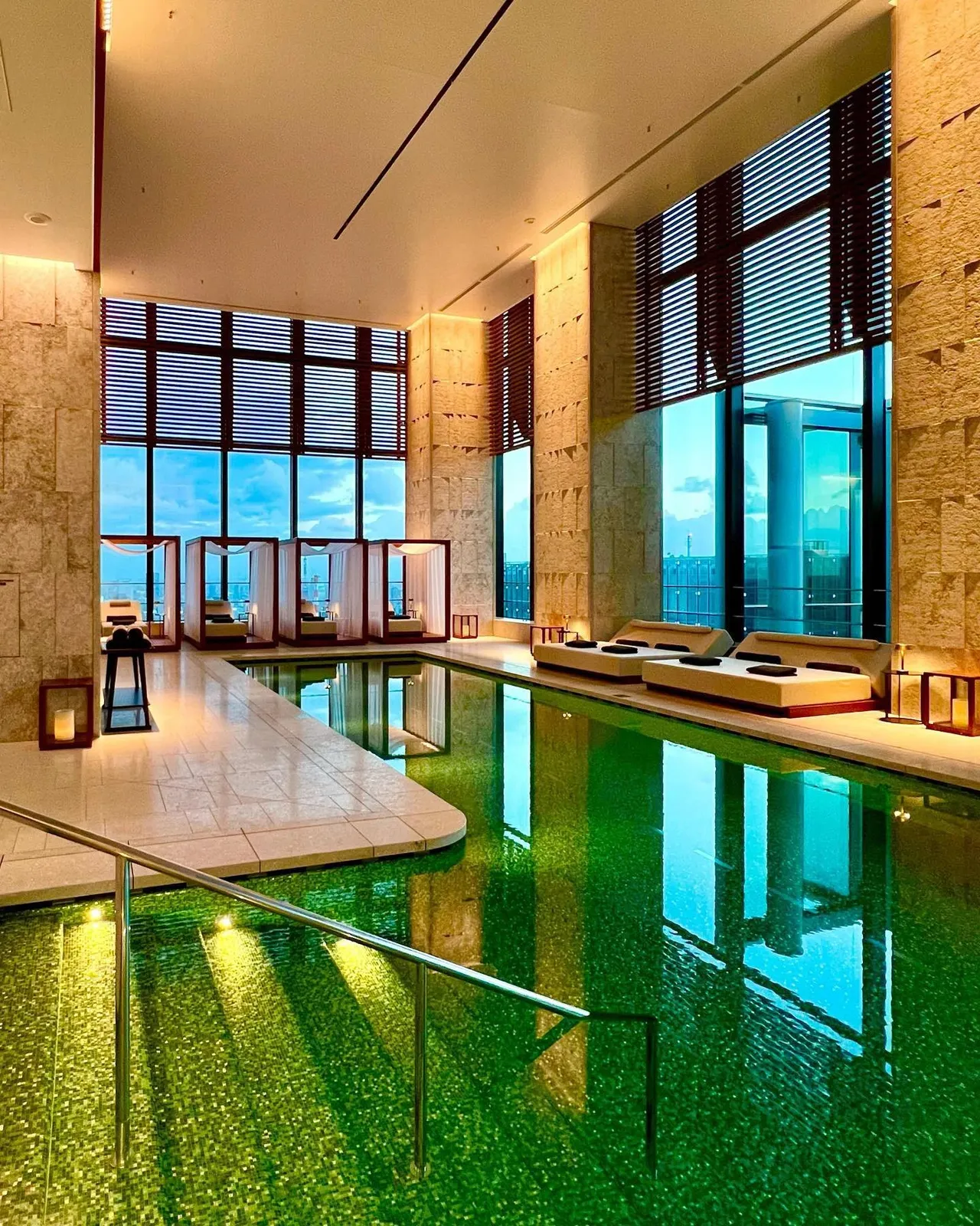 The green mosaic pool in a tall stone hall with city windows