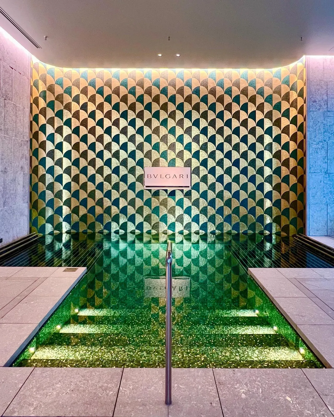 The emerald-mosaic soaking pool and Bulgari wall