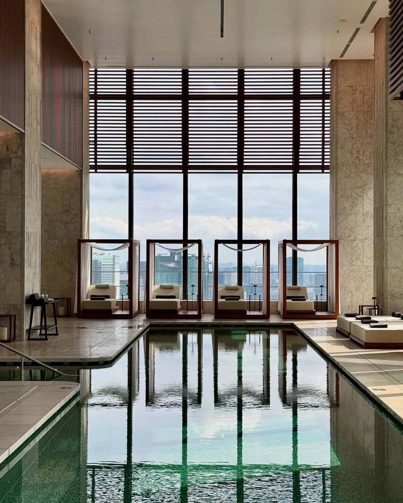 The pool reflecting the tall windows and daybeds