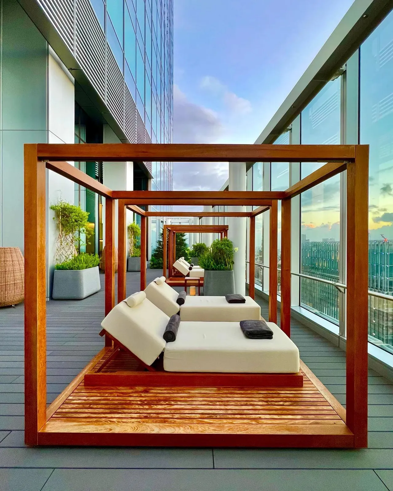 Wooden daybeds on the outdoor terrace high above the city