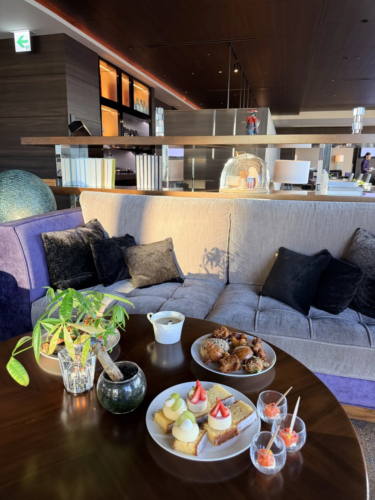 Afternoon sweets and savouries on a round table beside a sofa in the 39th-floor executive lounge