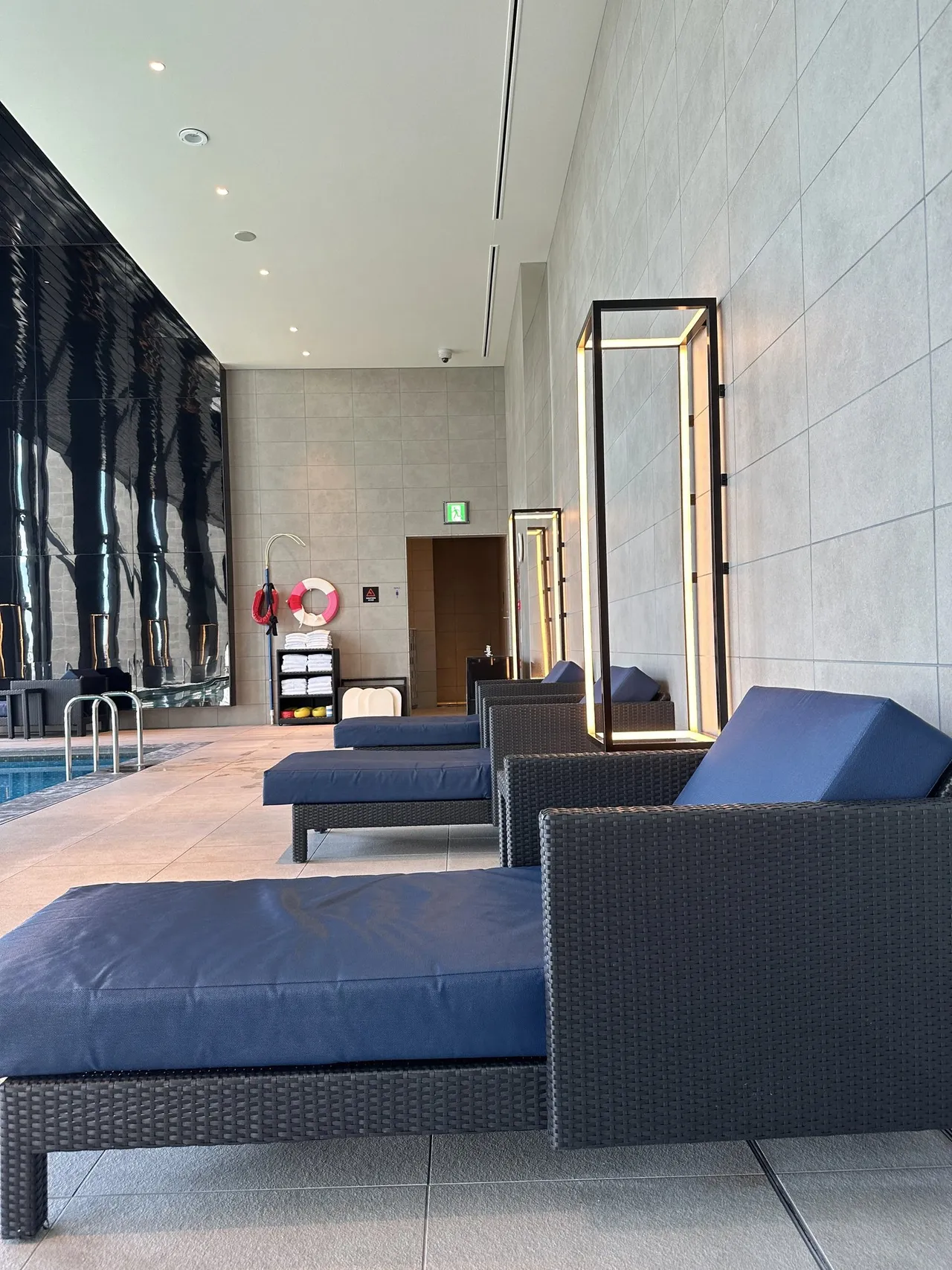 Blue loungers beside the pool in a stone-clad hall