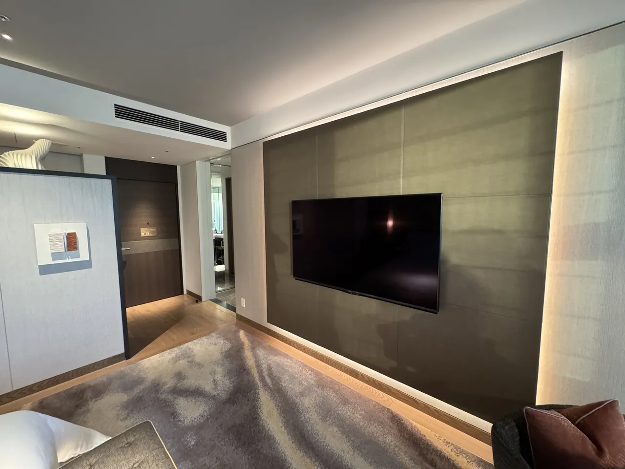 The soft-lit TV wall across from the bed