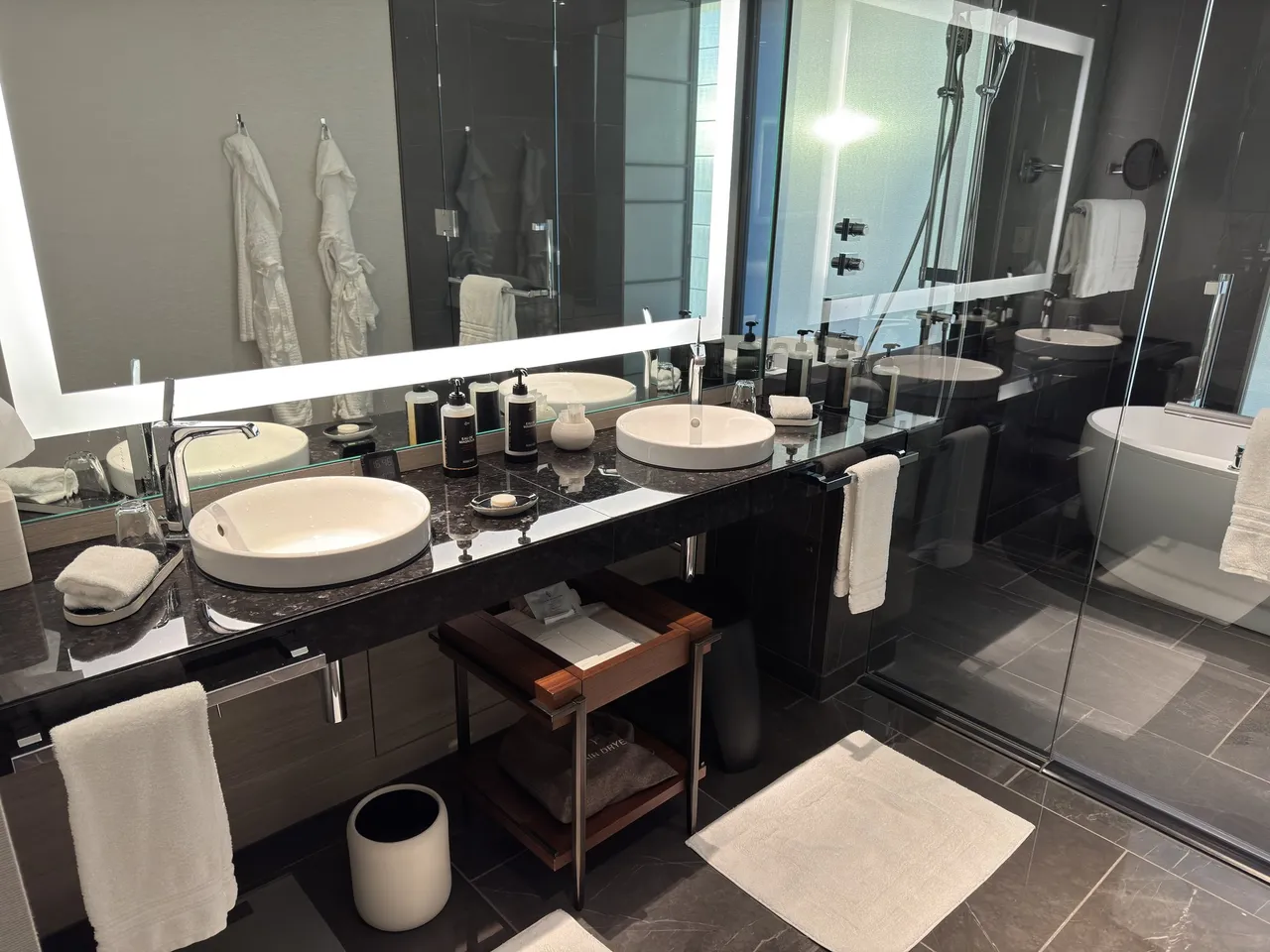 The double vanity with two stone basins, robes and glass shower