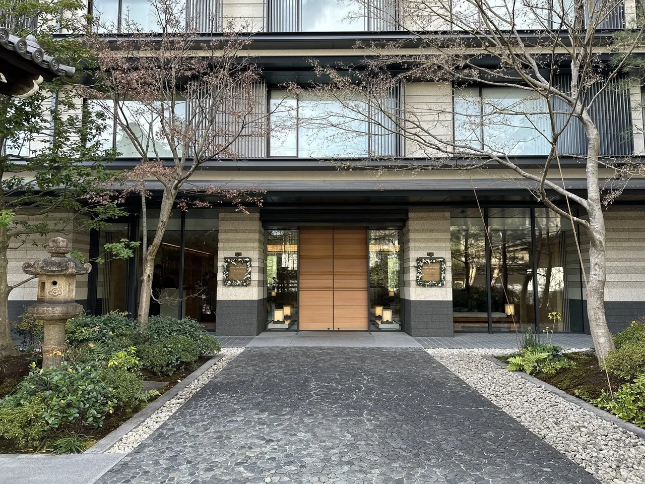 The hotel entrance up a cobbled path past a stone lantern