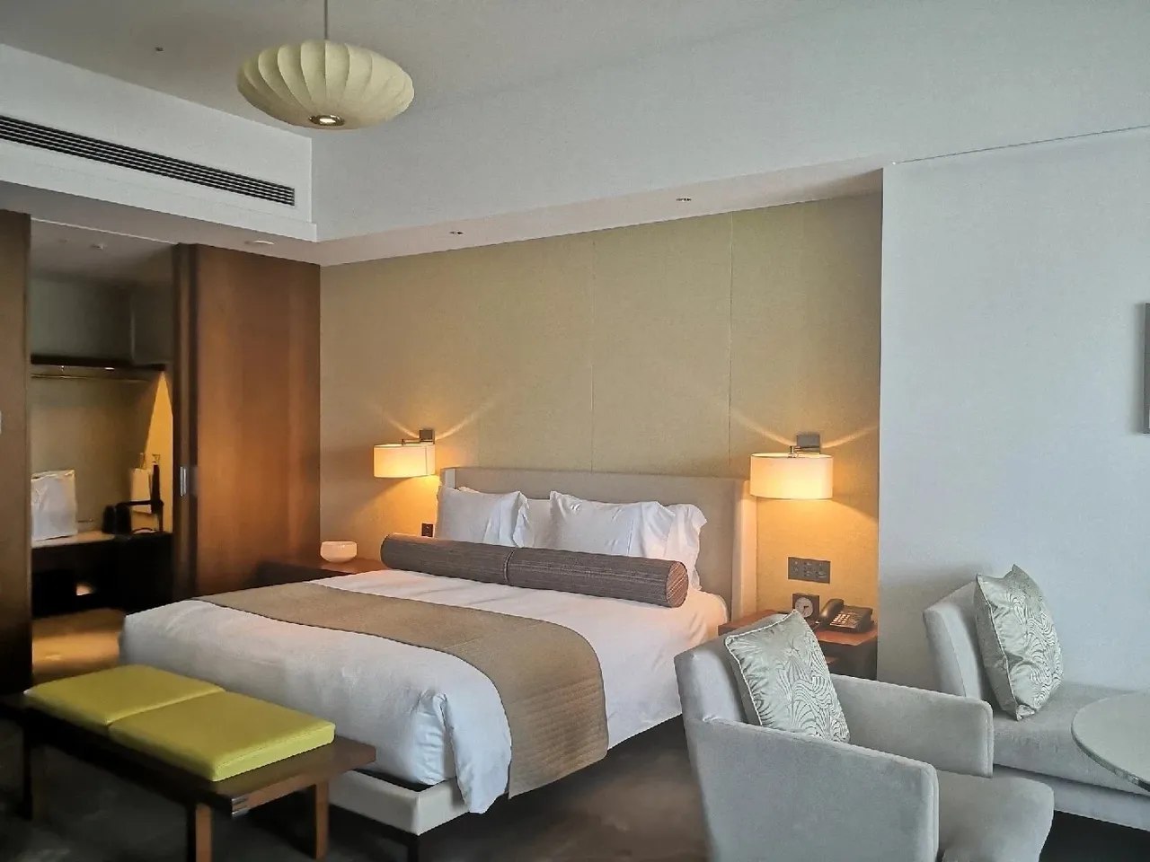 The balcony room with a wide bed, warm bedside lamps and an armchair by the window