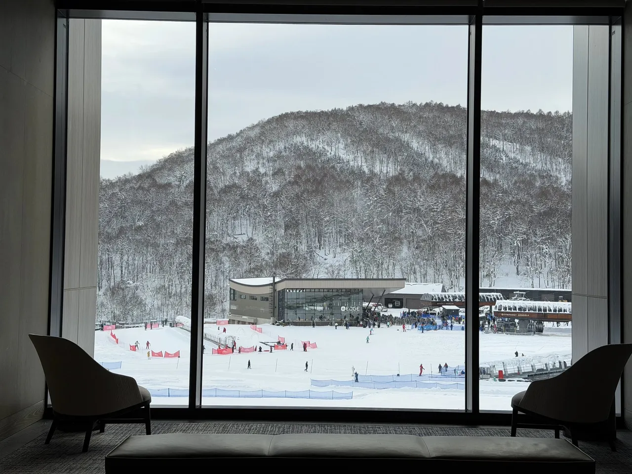 Lounge armchairs facing a big window onto the snowy ski slope