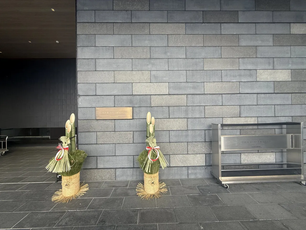 New-year kadomatsu decorations against the stone entrance wall