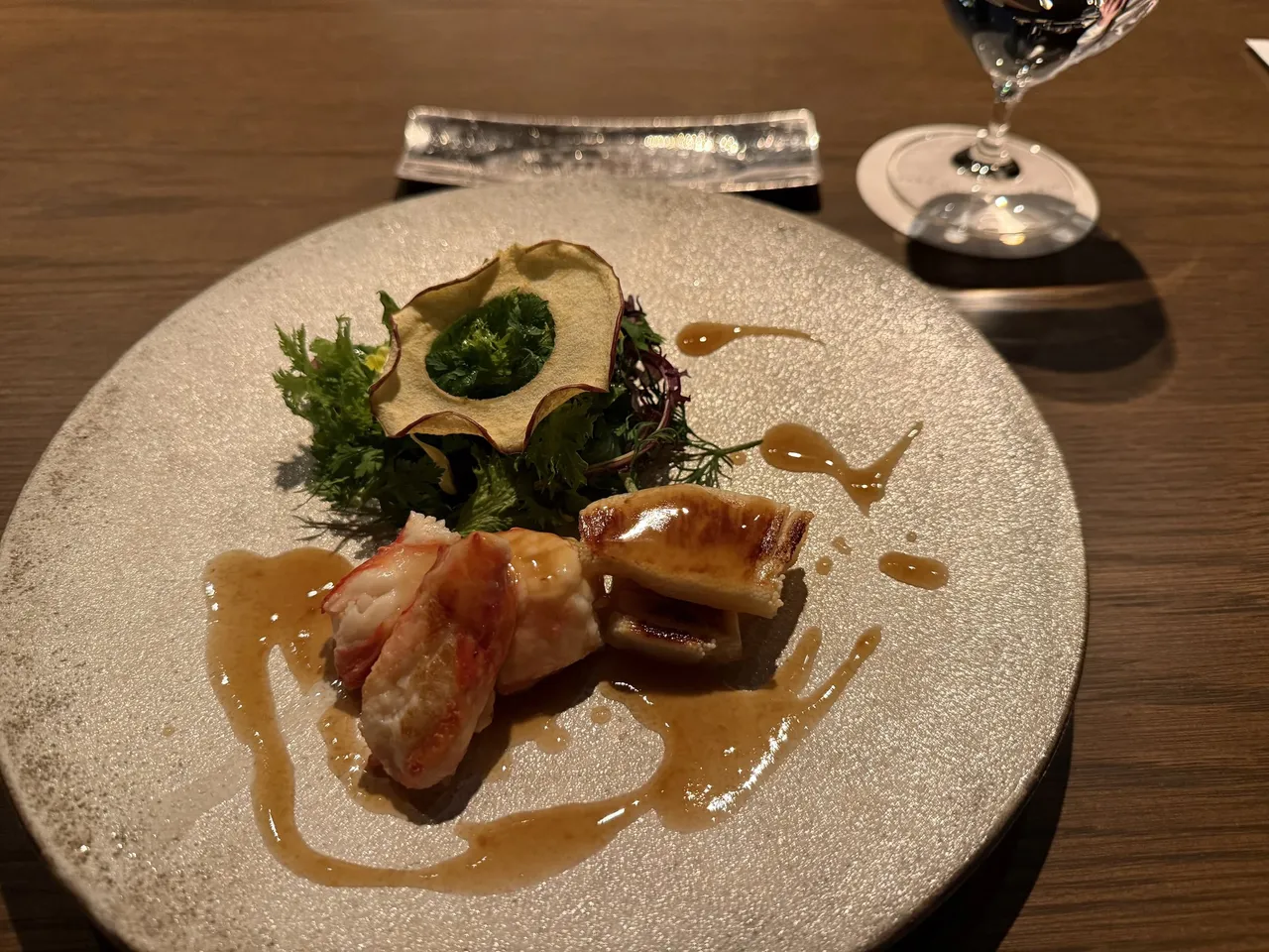 A seafood course in a rich sauce on a stone plate at the teppanyaki counter