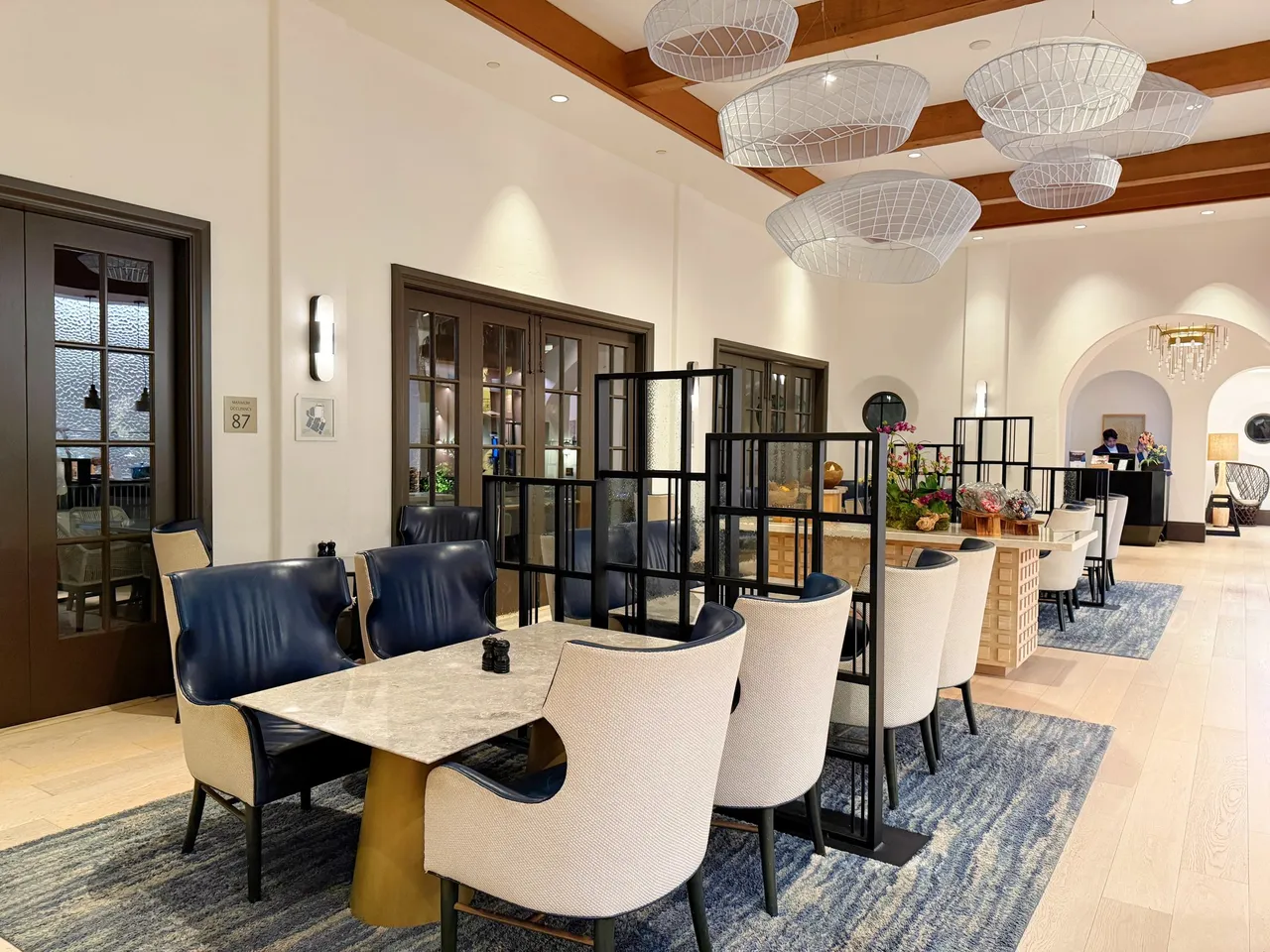 The bright club lounge dining room with blue chairs and timber beams