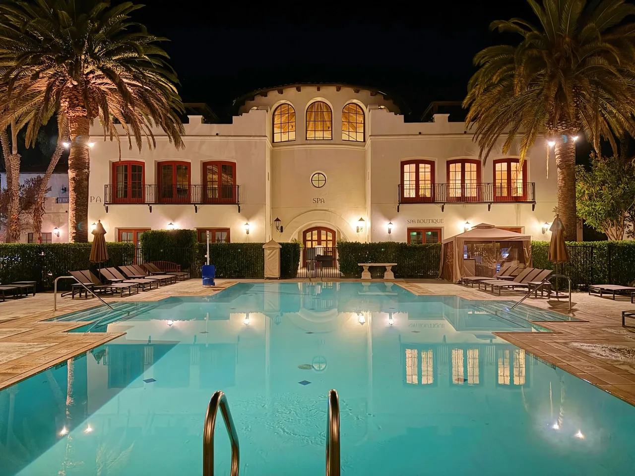 The adult pool at night in front of the lit facade