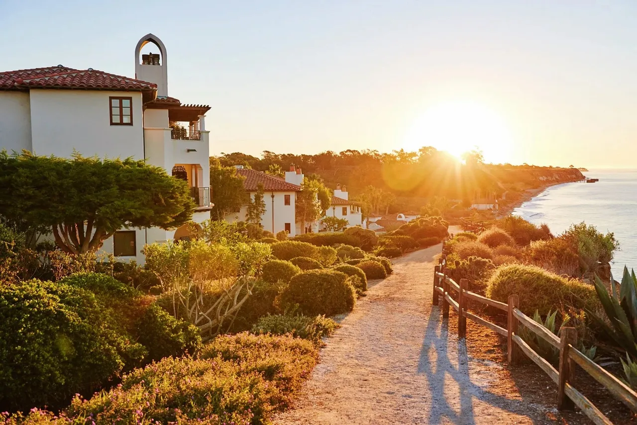 Sunset over the clifftop path and white villas