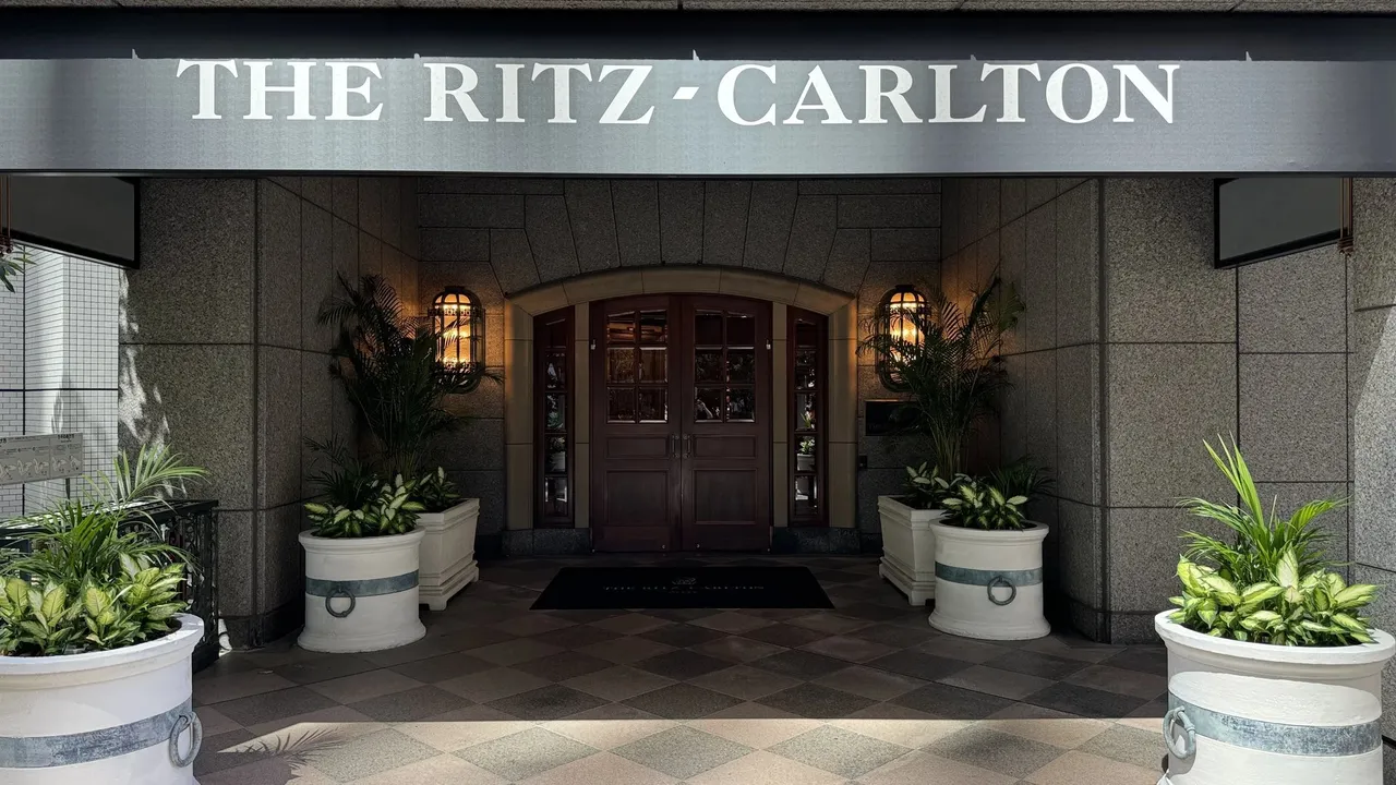 The Ritz-Carlton entrance canopy with potted plants and carved wooden doors