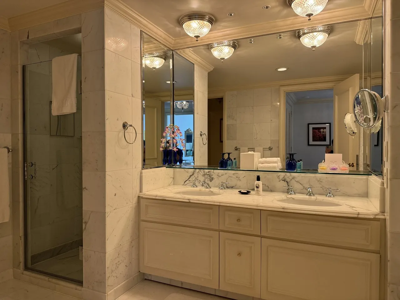 Cream marble vanity with a glass shower