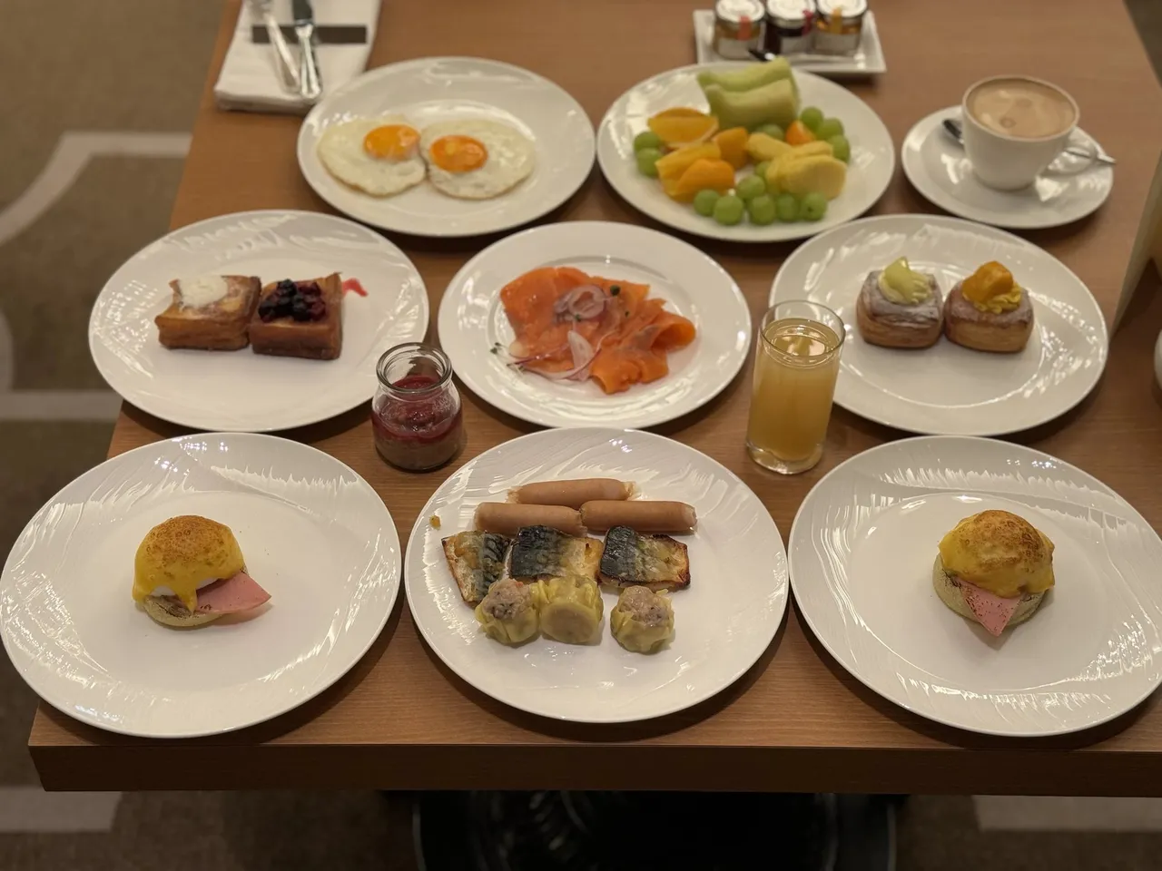 A breakfast table laid with eggs, salmon, pastries and fruit
