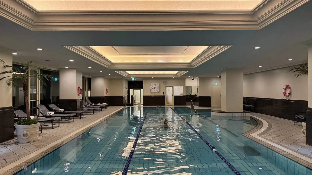 The indoor pool with lane ropes under a warm cove ceiling