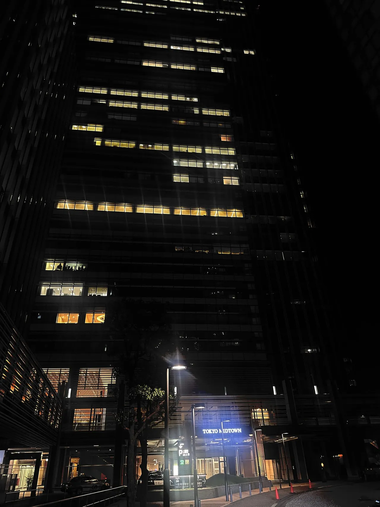 The tower lit at night with the hotel sign at its base