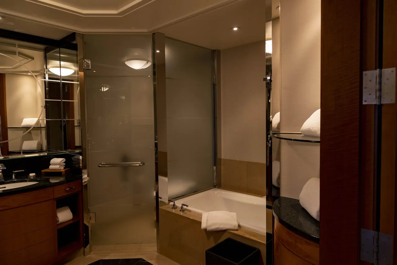 The bathroom with granite vanity, glass shower and soaking tub