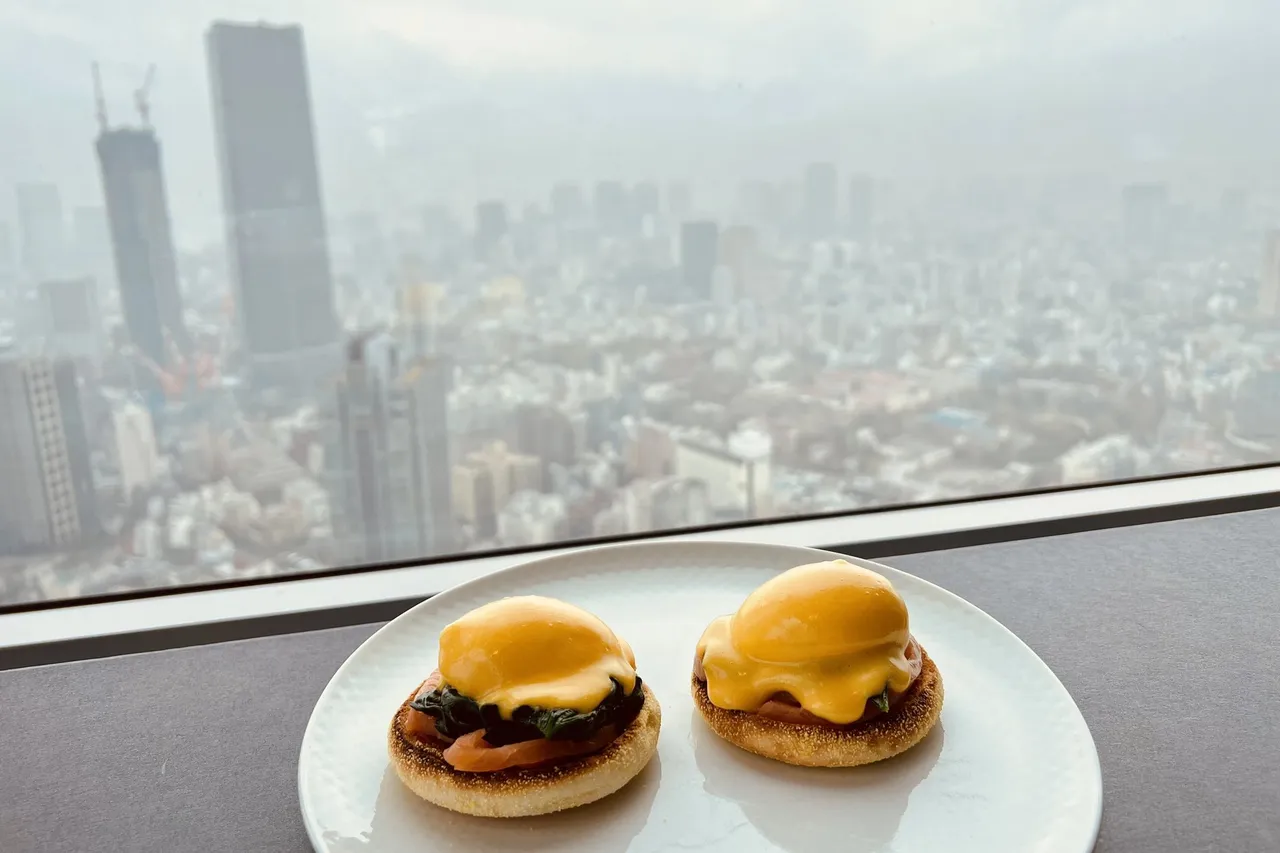 Eggs Benedict on the window ledge with a hazy tower beyond