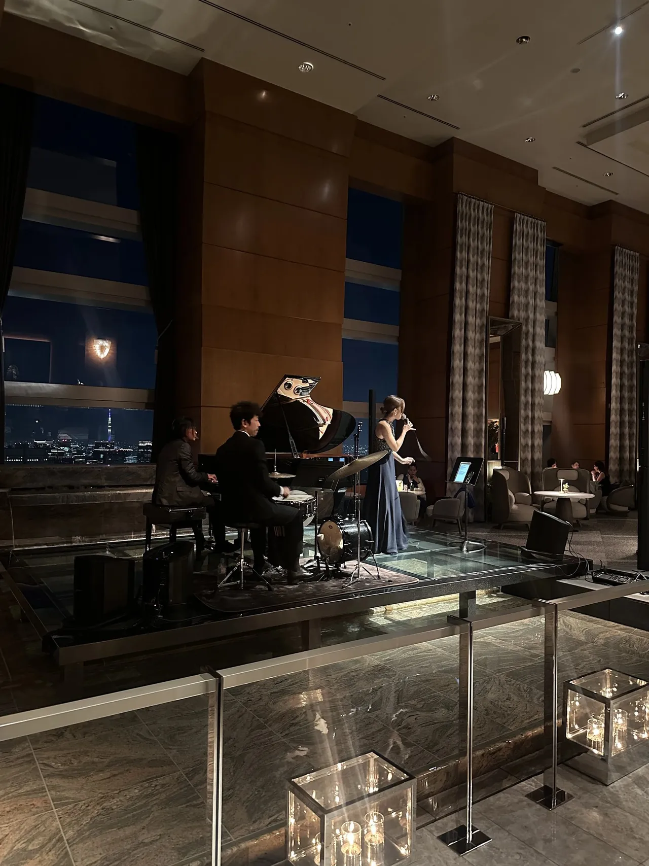 A live band playing in the bar beside tall windows