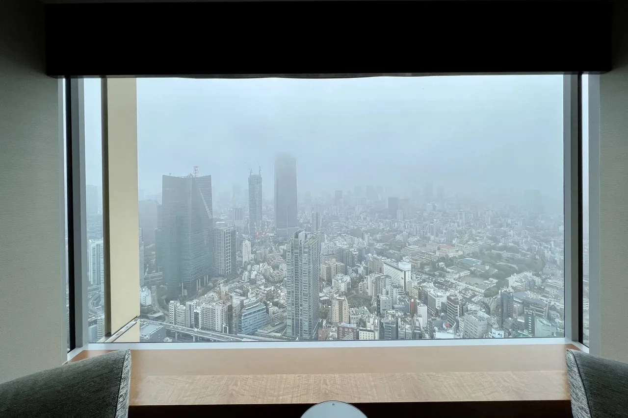 Fog-wrapped skyline seen through a framed window at breakfast